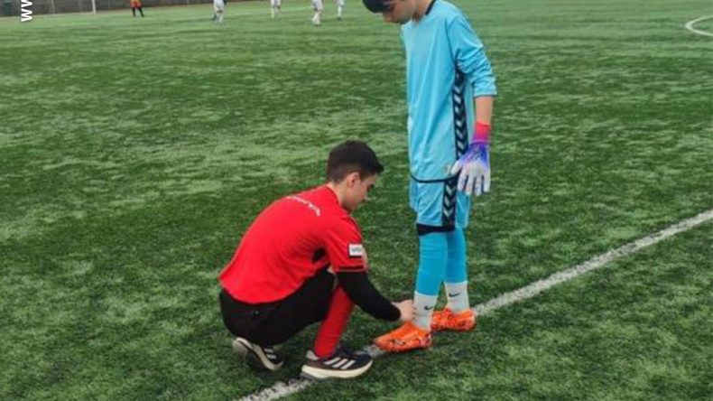 Hakem futbolcunun kramponlarını bağladı